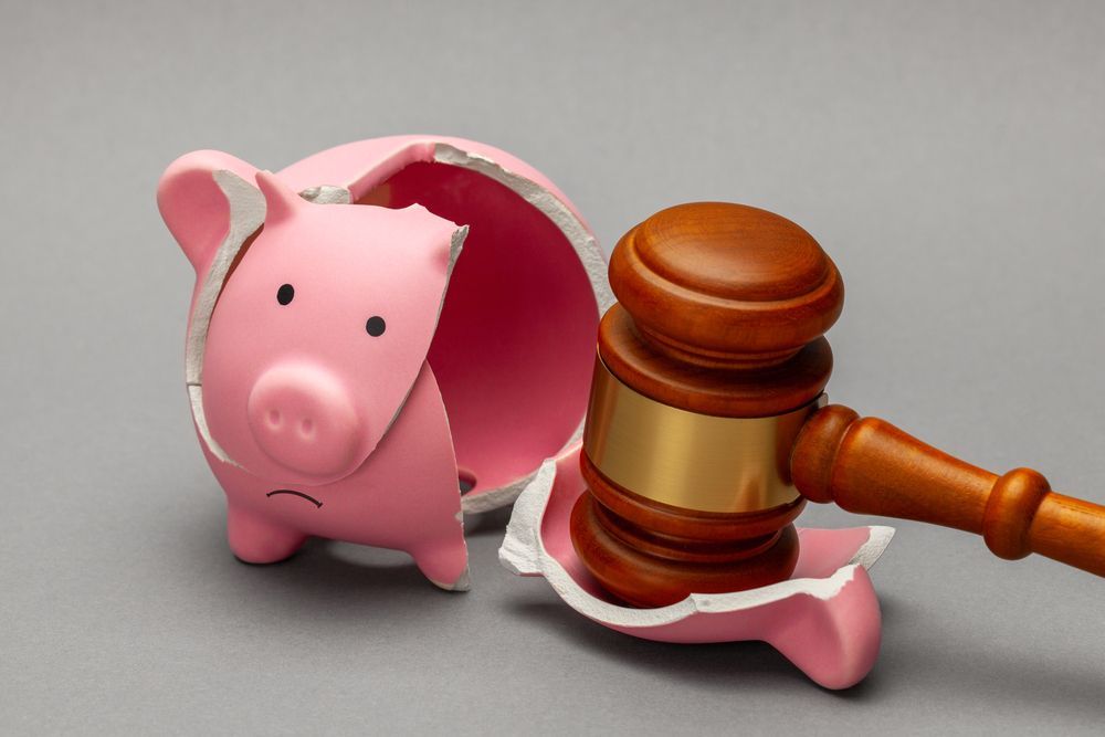 Judge gavel smashing a pink piggy bank