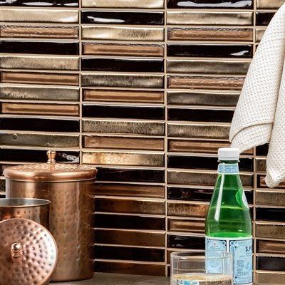Tile backsplash with various shades of brown and gold. Copper accessories and a water bottle are visible.