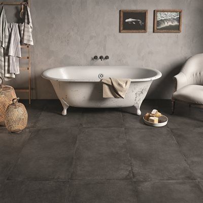 Bathroom with a claw-foot tub, dark tiled floor, neutral walls, and wicker baskets.