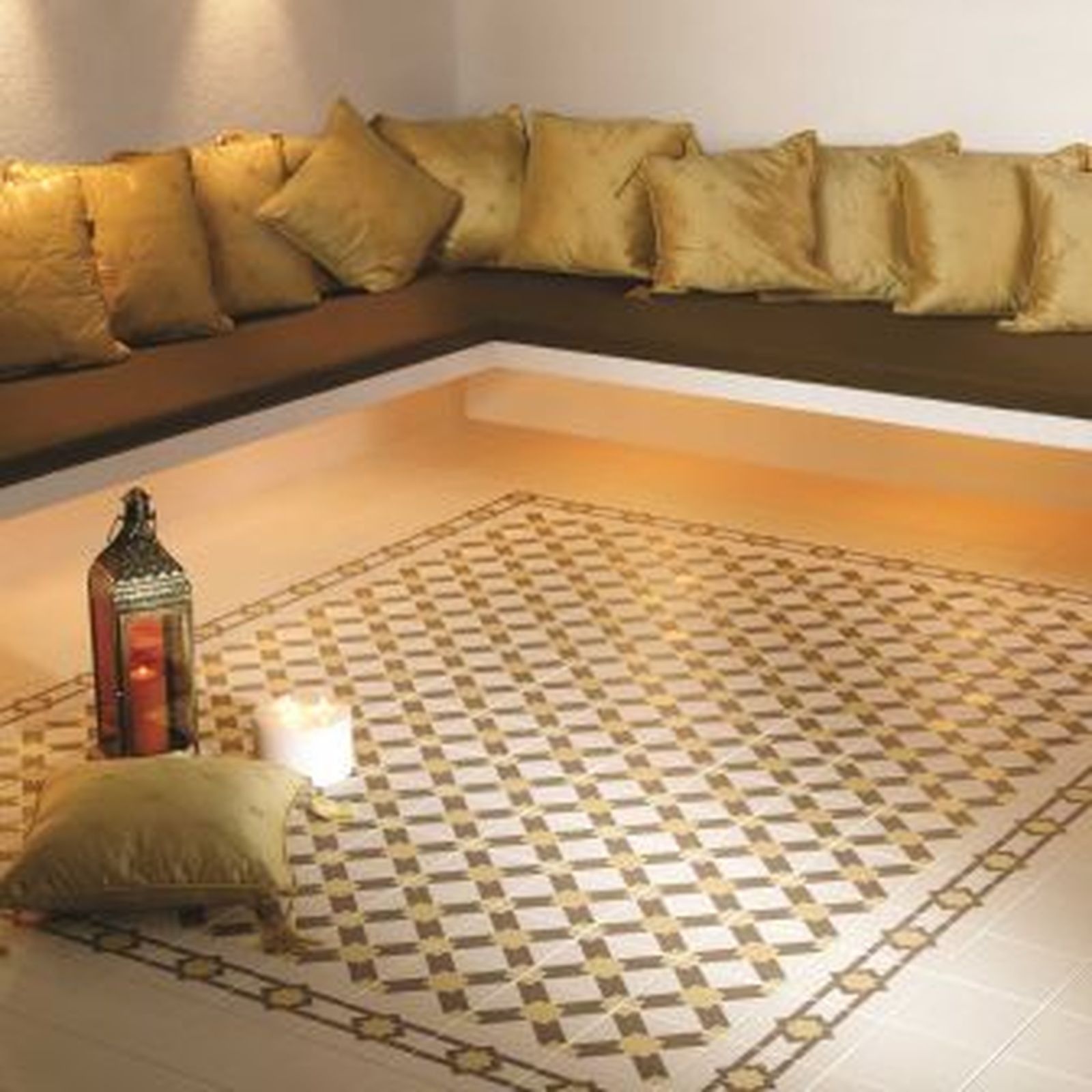 Cozy seating area with gold pillows, tiled floor with geometric pattern, and candle lantern.