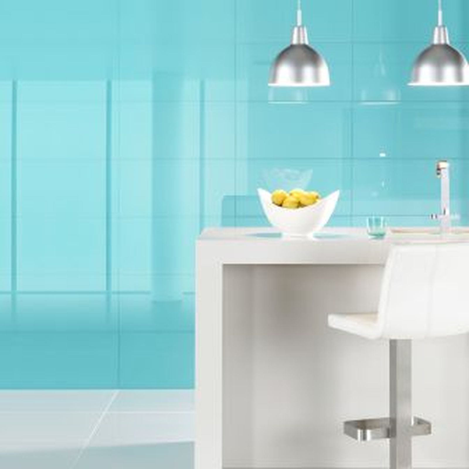 Modern kitchen with turquoise backsplash, white island, pendant lights, and stool.