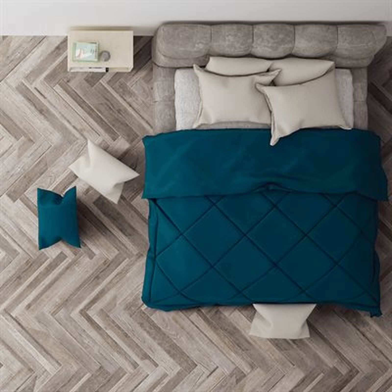 Overhead view of a bed with teal comforter, white pillows, and wood floor. A nightstand is at the head of the bed.