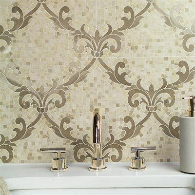 Bathroom backsplash with beige and brown floral tile pattern, gold faucet and fixtures.