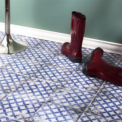 Blue and white patterned tile floor with red rain boots and a silver bar stool leg.