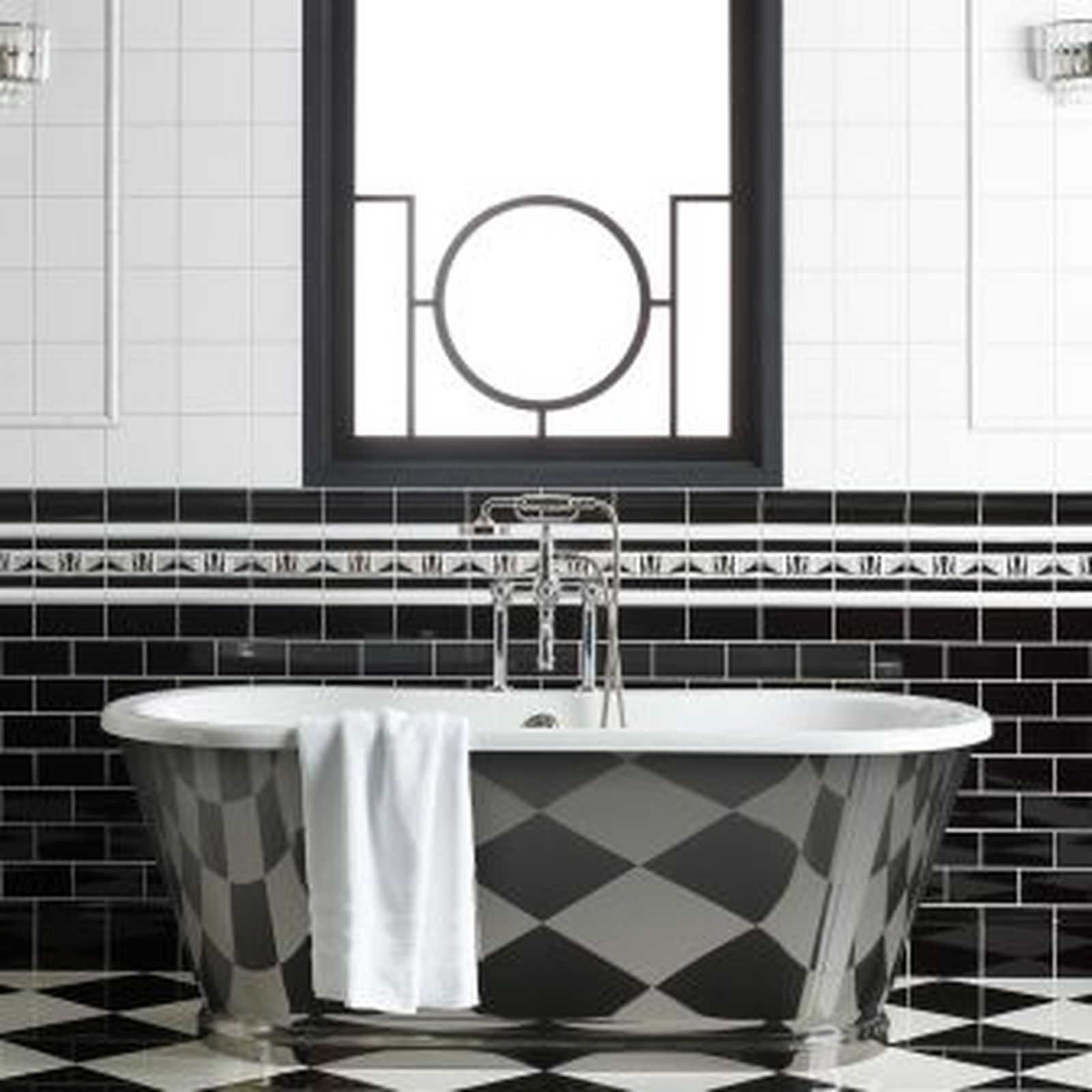 Bathroom with black and white diamond-patterned tub and matching tiled walls and floor.