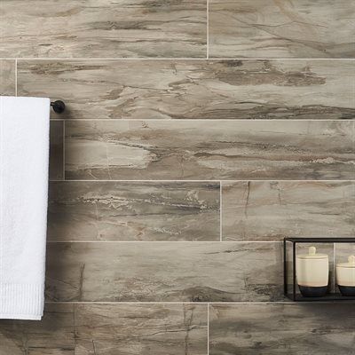 Wood-look tile wall with a white towel on a dark rod and a shelf with containers.