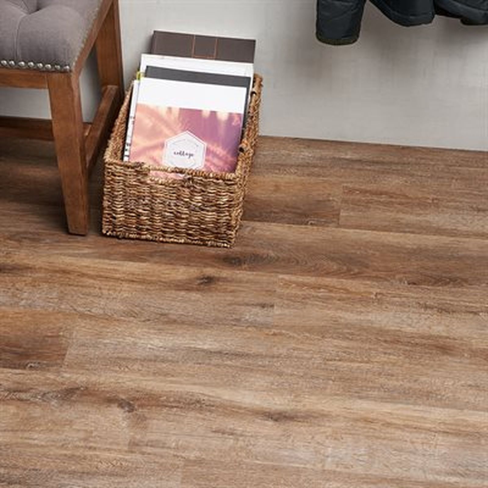 Wooden floor with a basket of items, bench, and coat.
