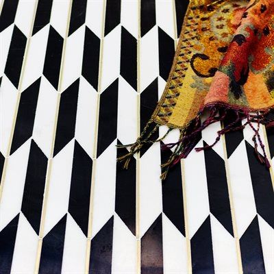 Black and white chevron tile with a colorful scarf draped on top.