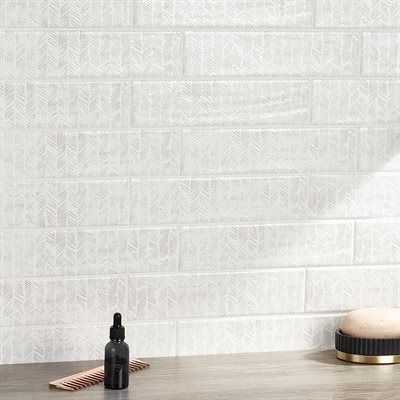 White patterned subway tile background with a bottle and a soap dish.