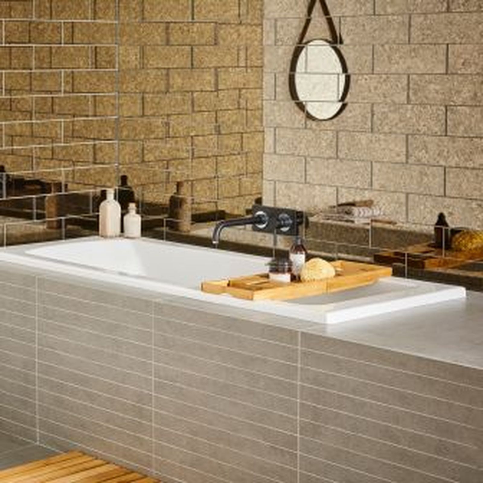 Modern bathroom with a bathtub, wood tray, and a brick-patterned wall.