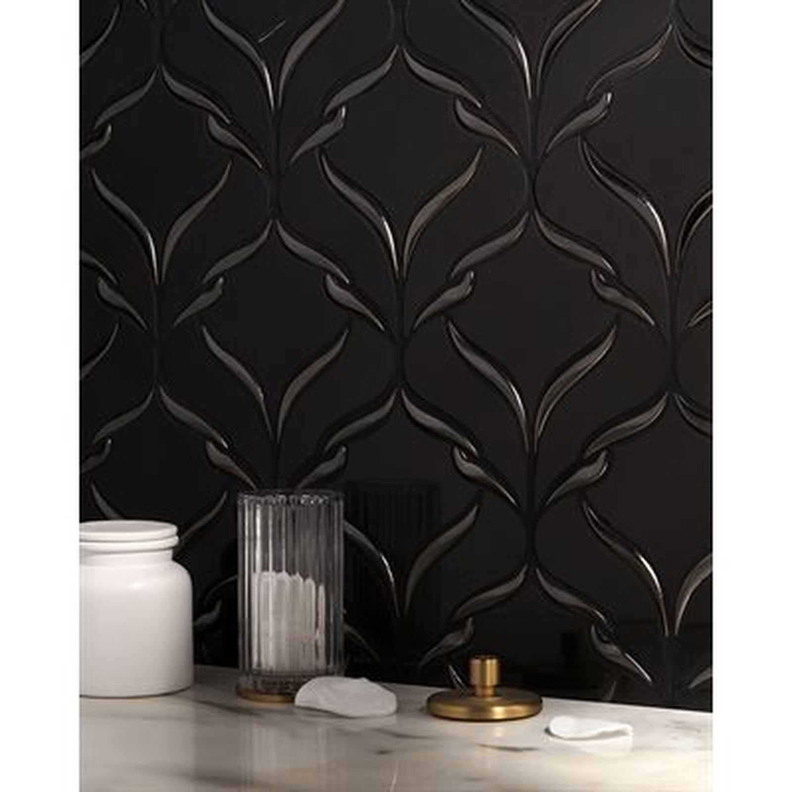 Black tile backsplash with raised floral design, bathroom setting, objects on countertop.