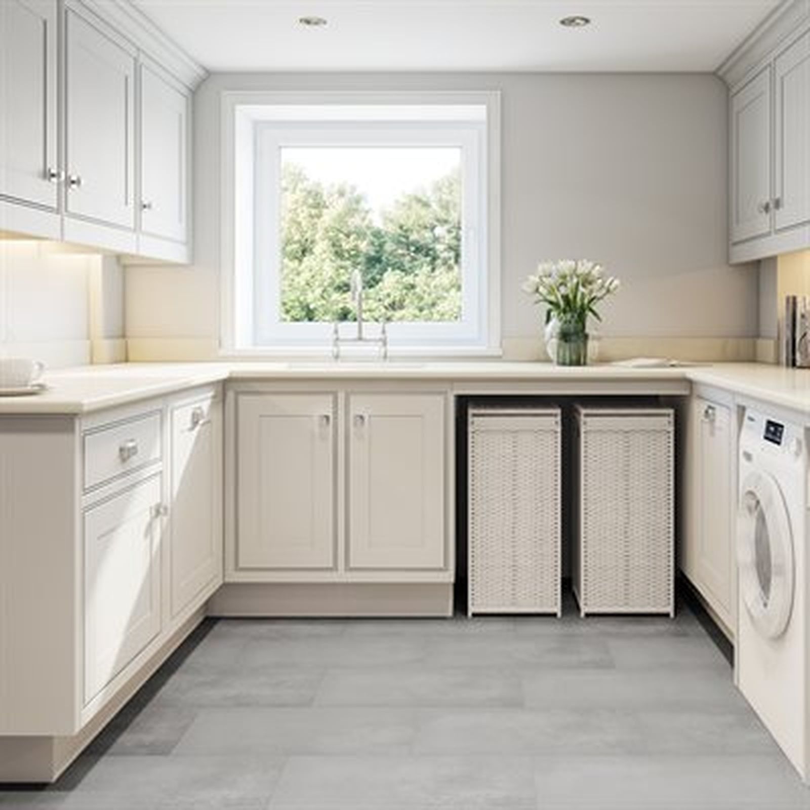 A bright, white laundry room with cabinets, a window, washing machine, and laundry hampers.