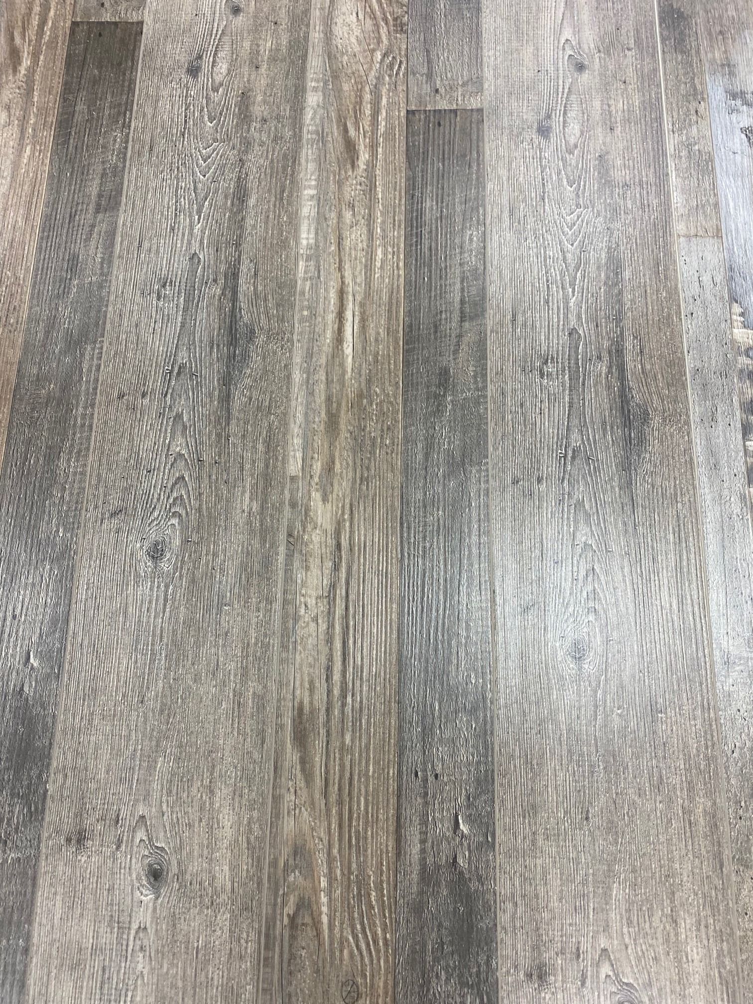 Gray wood-look flooring with vertical planks and textured grain patterns.