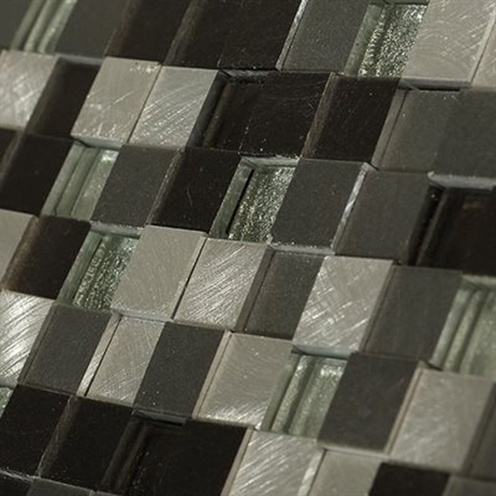 Close-up of a tiled surface in a checkerboard pattern of silver, black, and clear glass squares.