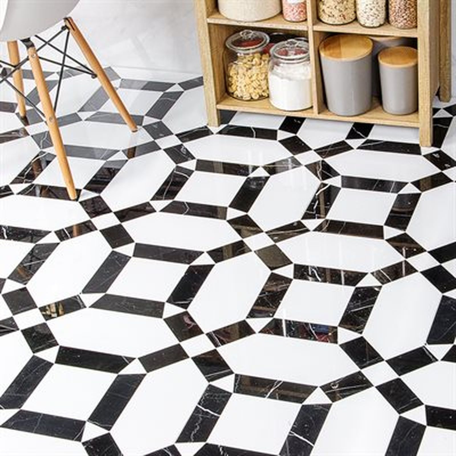 Black and white patterned tile floor with a wooden shelf and chair legs in view.
