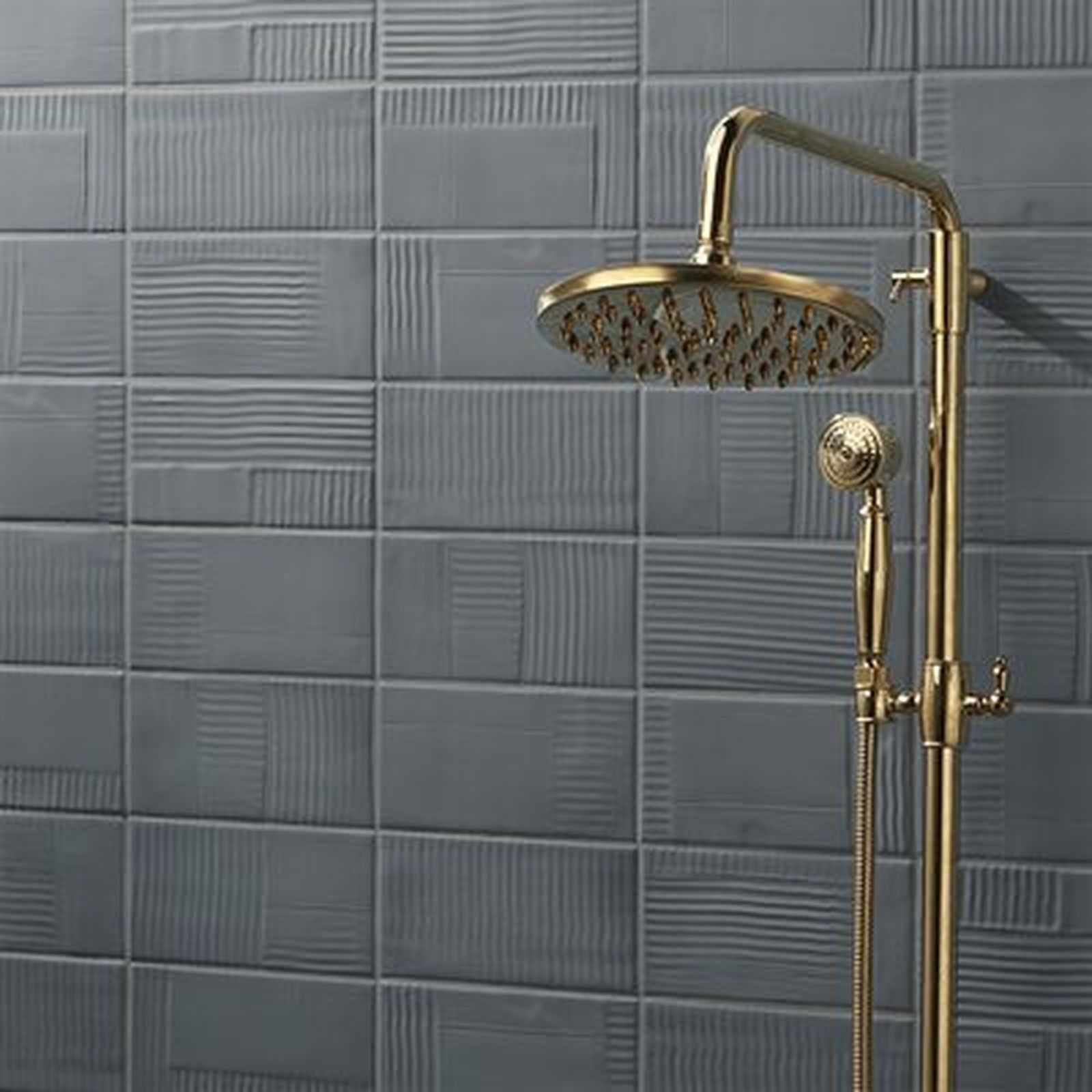 Gold shower fixture against gray textured tile wall.