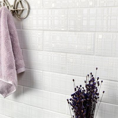 White textured tile wall with a lavender towel and dried flowers.