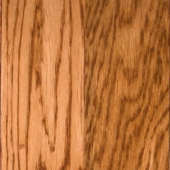 Close-up of hardwood flooring; light brown oak planks with visible grain and dark brown streaks.