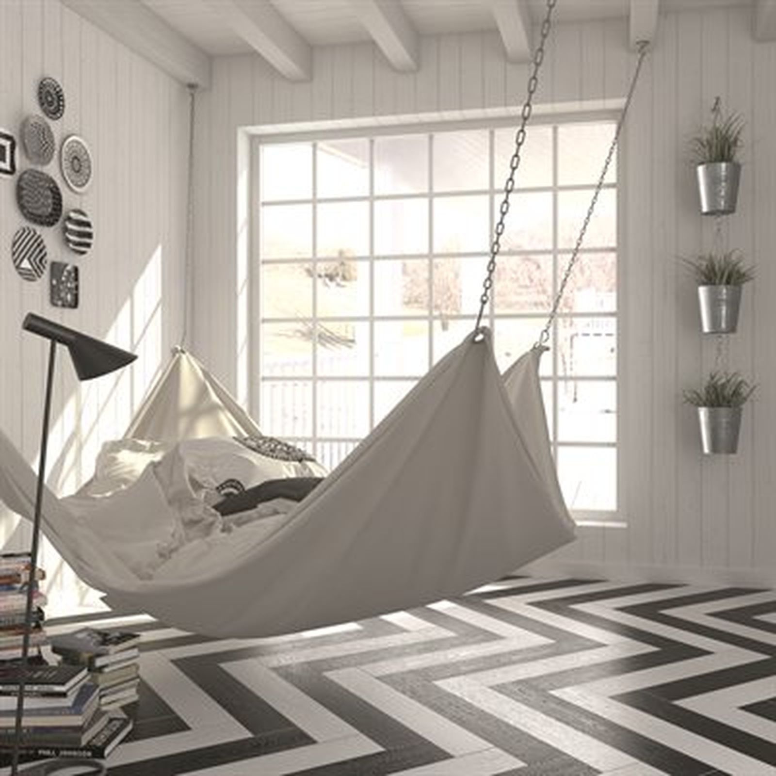 A bright room with a hanging bed, large window, and black and white zigzag floor.