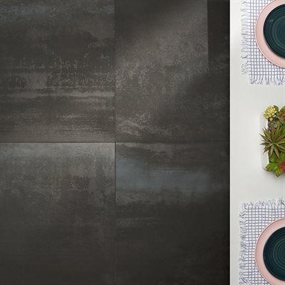 Dark, textured square tiles beside a white table. Two place settings are on the right side.