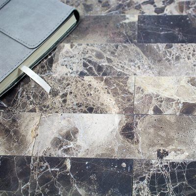 Gray leather-bound journal with a bookmark on a marble-tiled surface.