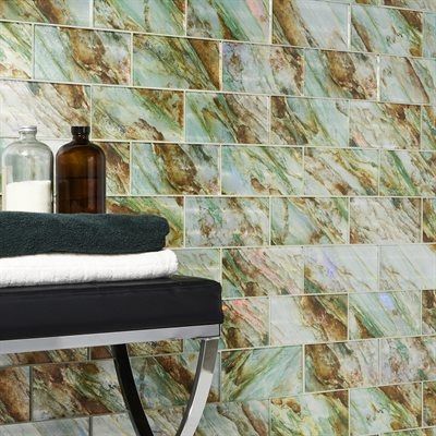 Wall with green and brown marble-look tiles, towels, and apothecary bottles.