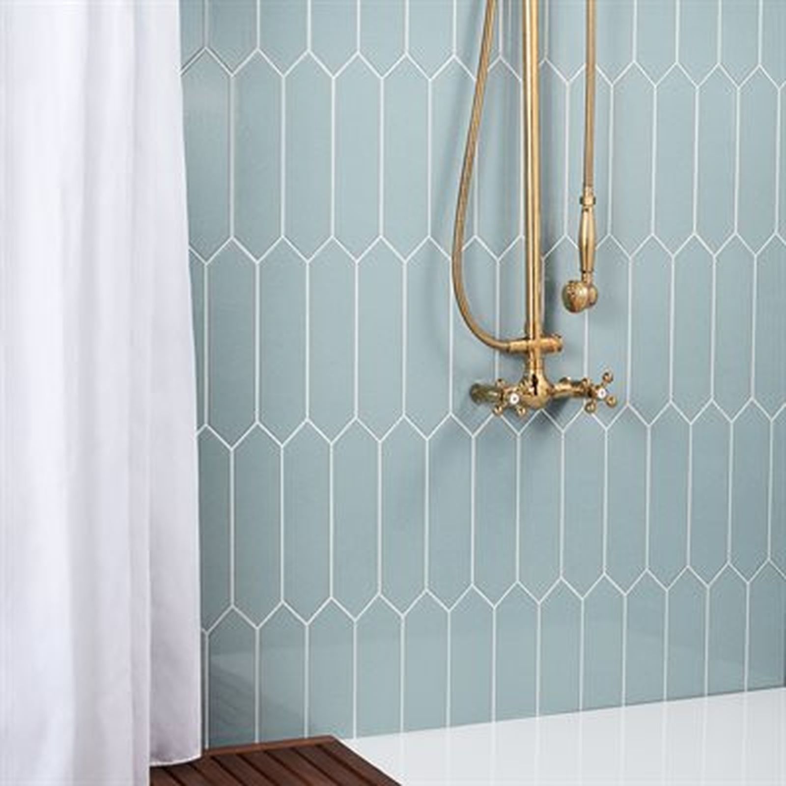 Blue tile shower with gold fixtures and white curtain.