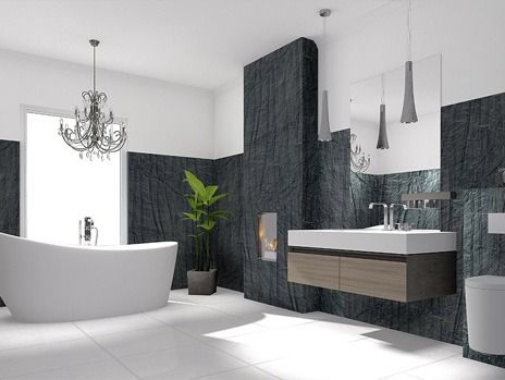 Modern bathroom with a white bathtub, dark accent walls, and a chandelier.