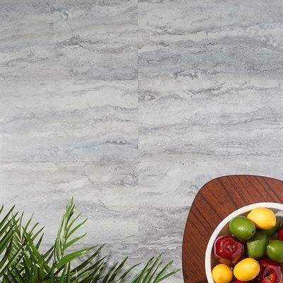 Marble-look tiled background with a wooden platter of fruit and green leaves in the corner.
