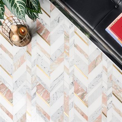 Herringbone marble floor with pink and gold accents; plant, candles, and black seat visible.