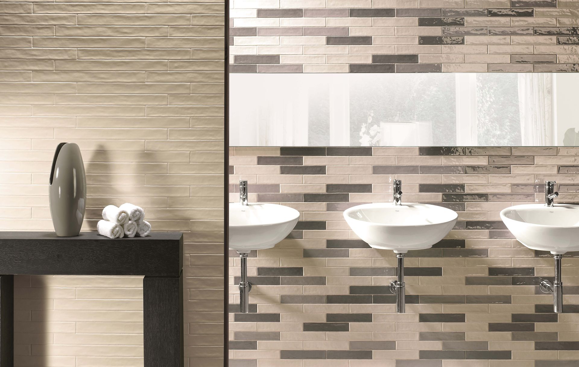 Bathroom with three sinks, mirror, and textured tile wall. A vase and towels are on a dark counter.