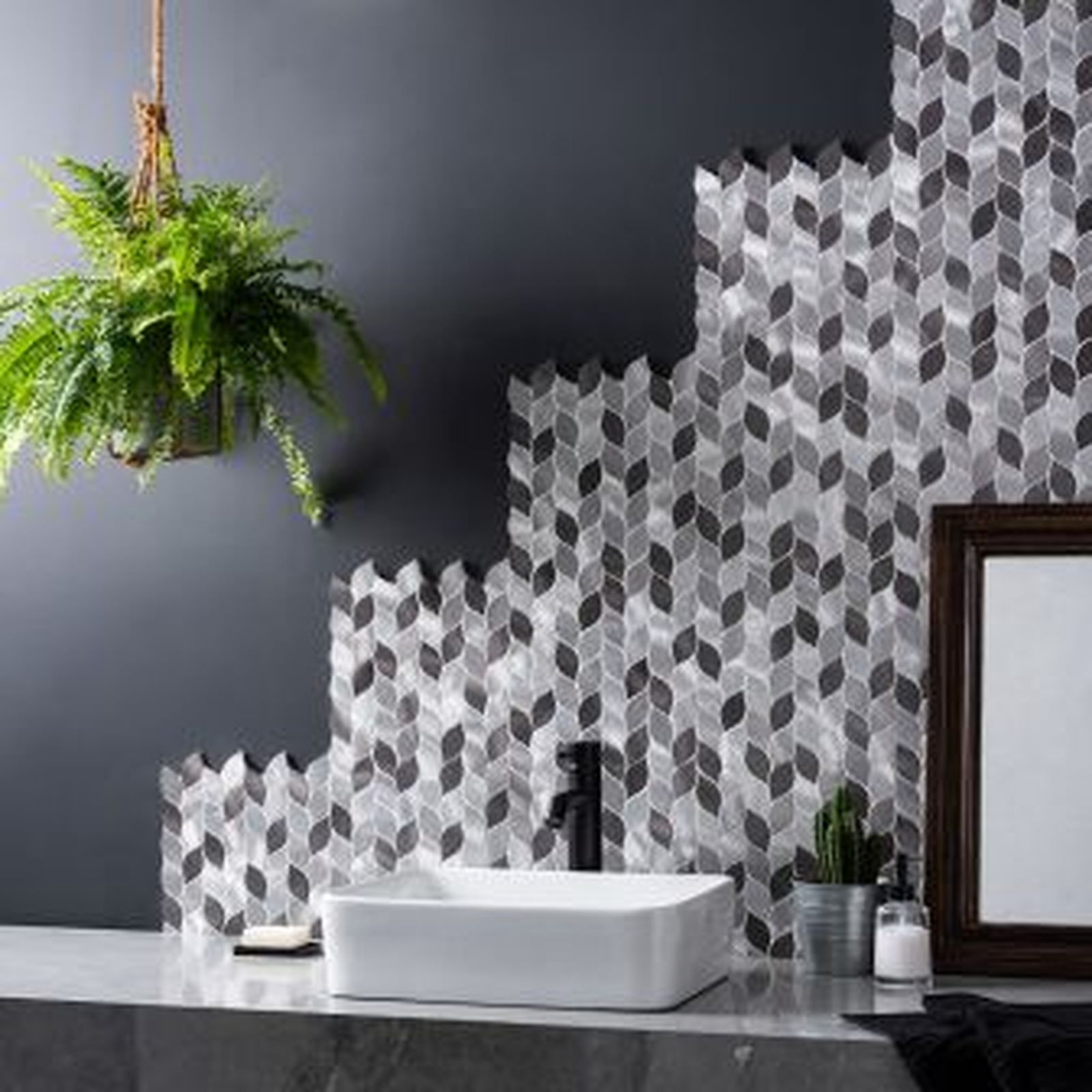 Bathroom with leaf-patterned tiles, a hanging plant, a white sink, and decorative elements.