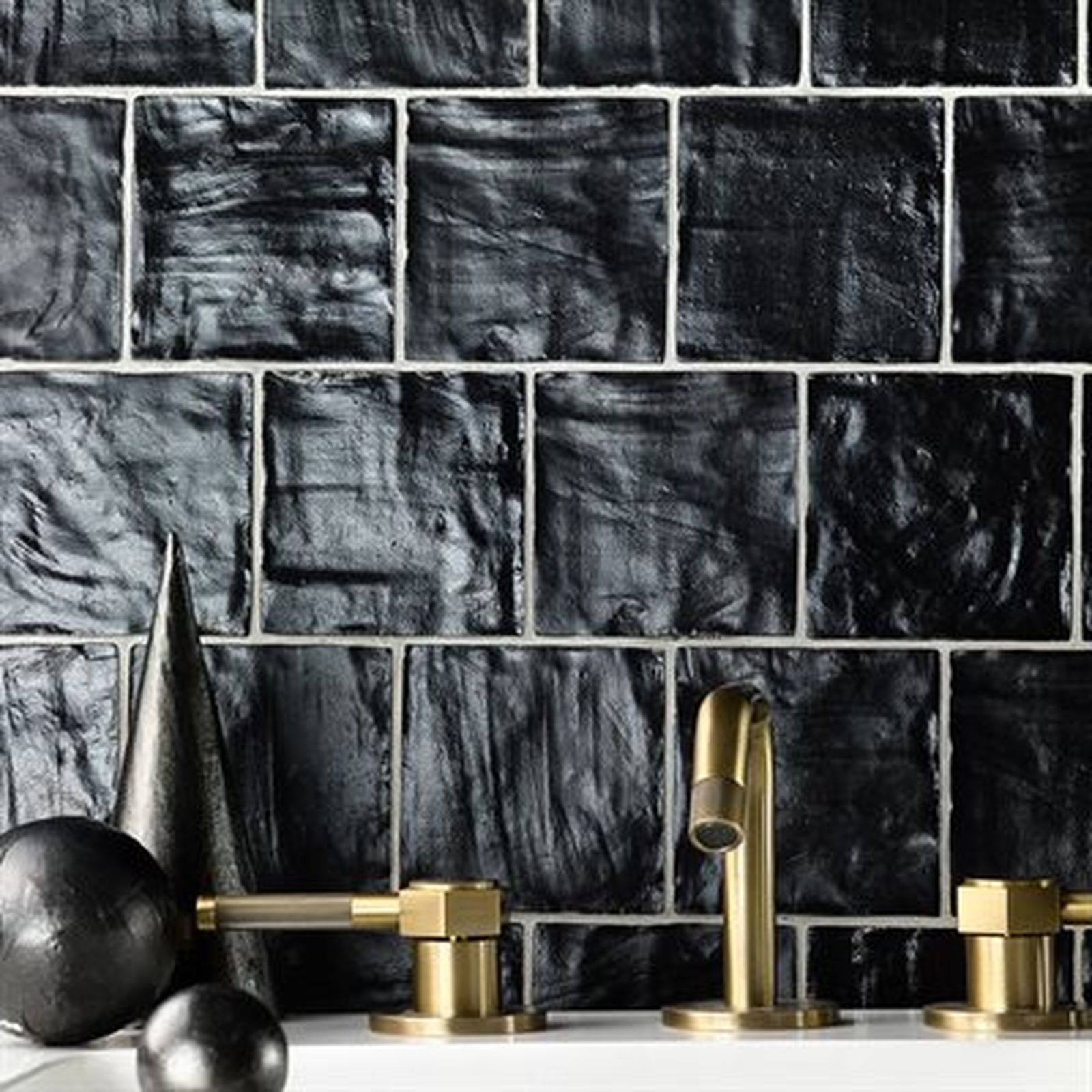 Black glazed tile backsplash with gold faucet and fixtures.