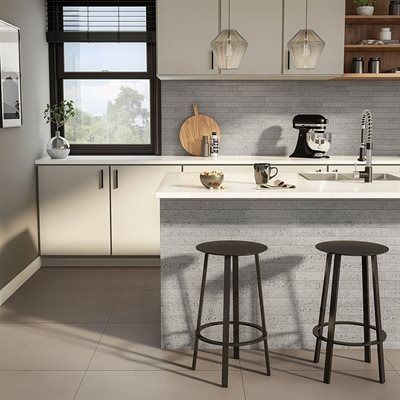 Modern kitchen with a breakfast bar and two stools, neutral tones, and a window.