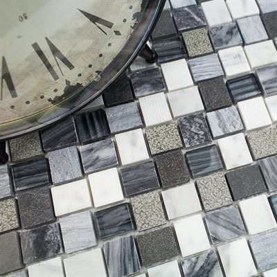 Clock resting on a mosaic tile surface with squares of white, gray, and black.