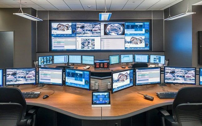 Una sala de control llena de muchos monitores de computadora y tabletas.