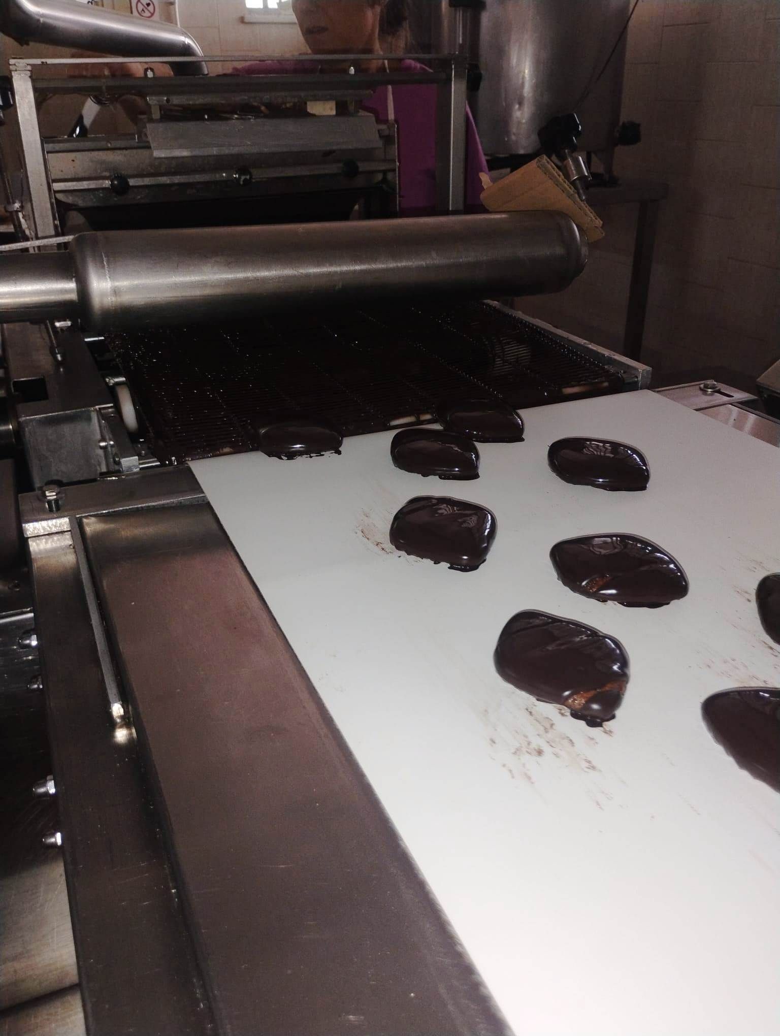 Impasto di cioccolato distribuito su un nastro trasportatore.