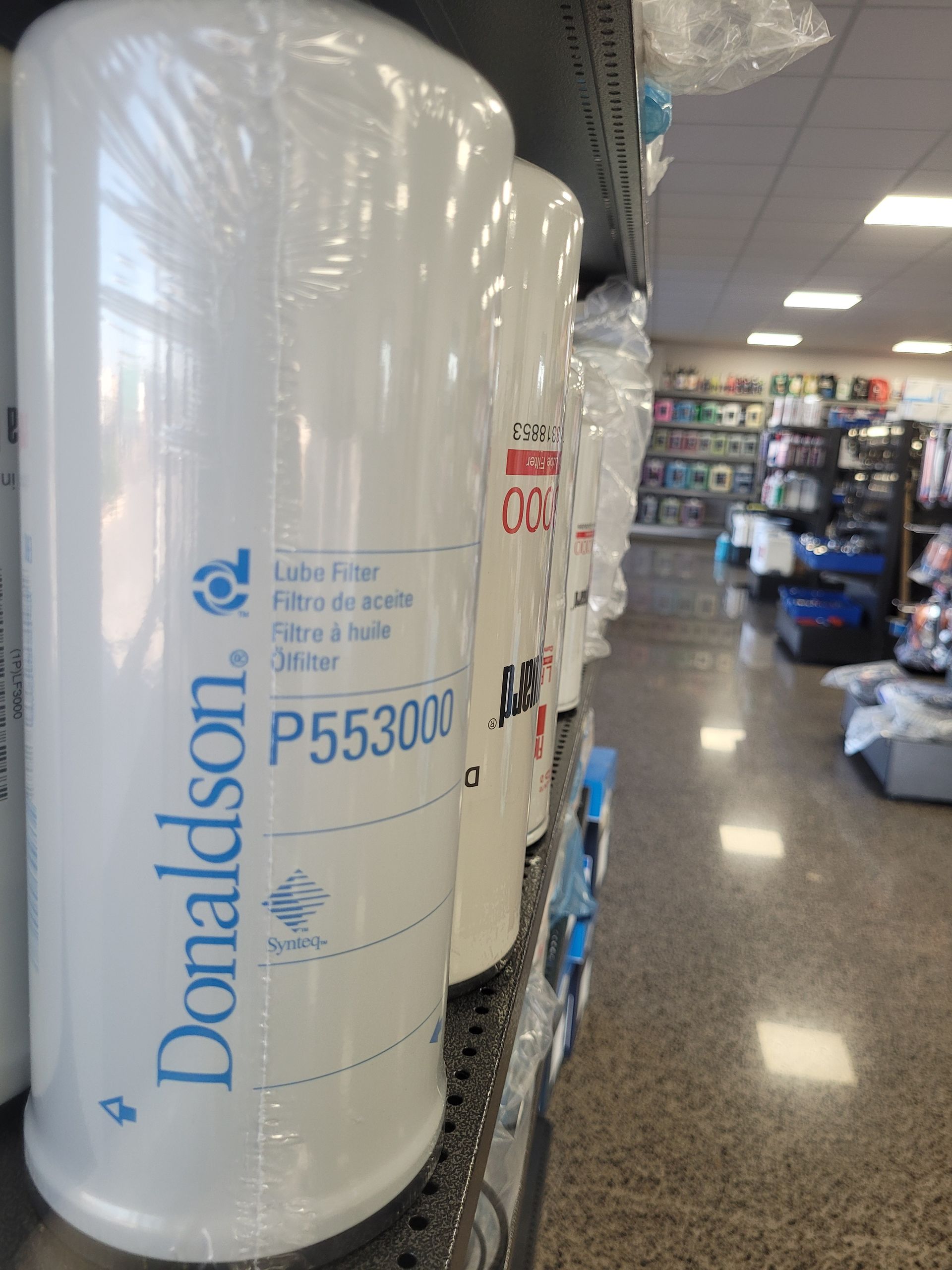 White Donaldson oil filters in plastic wrap on a store shelf, displaying model number P553000 — Top End Diesel In Wishart, NT
