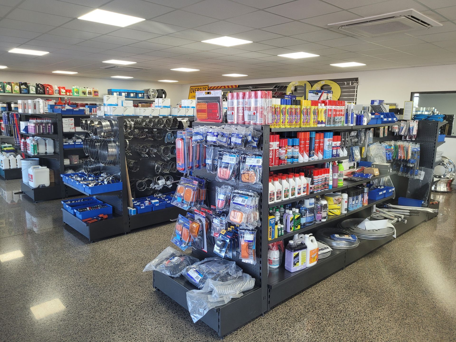 Interior of a well-lit auto parts store with shelves stocked with various products, including fluids, tools, and accessories — Top End Diesel In Wishart, NT