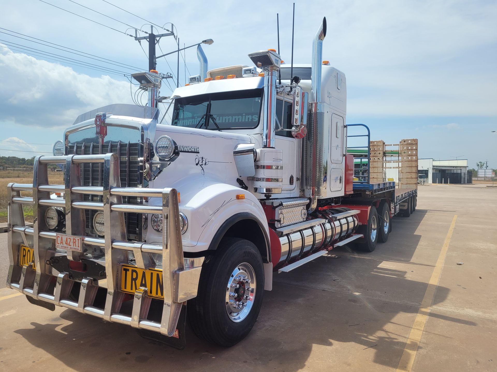 Red semi-truck driving on a highway, trees and a bridge in the background. — Top End Diesel In Wishart, NT