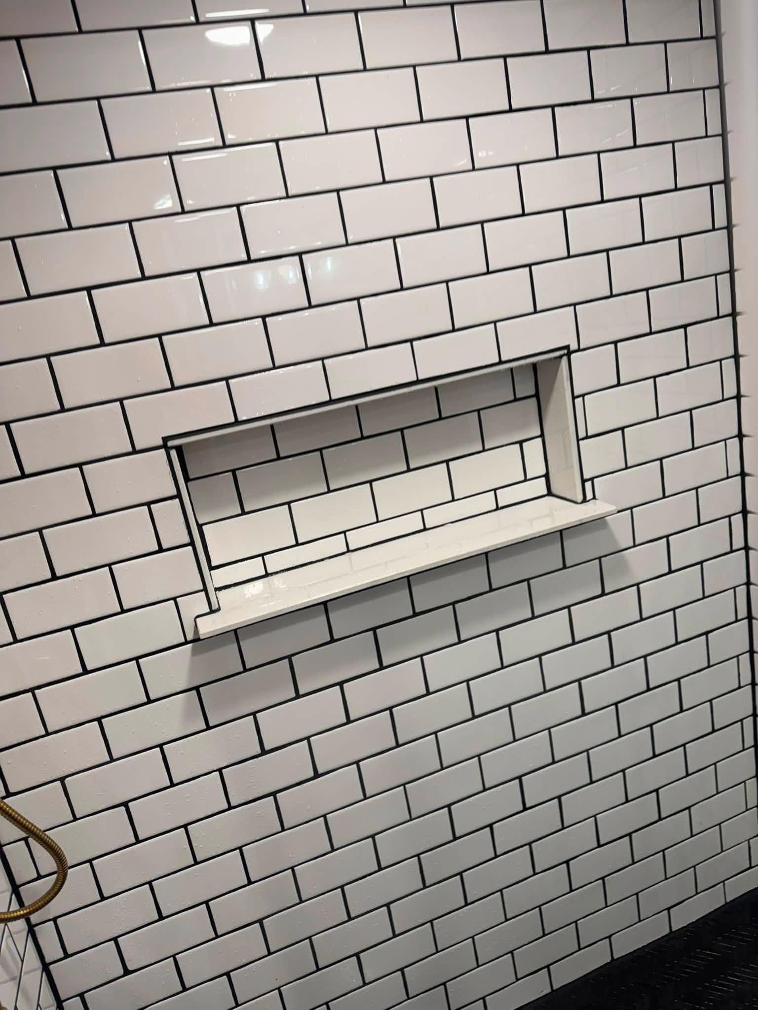 White tiled wall with a recessed rectangular niche or shelf opening.
