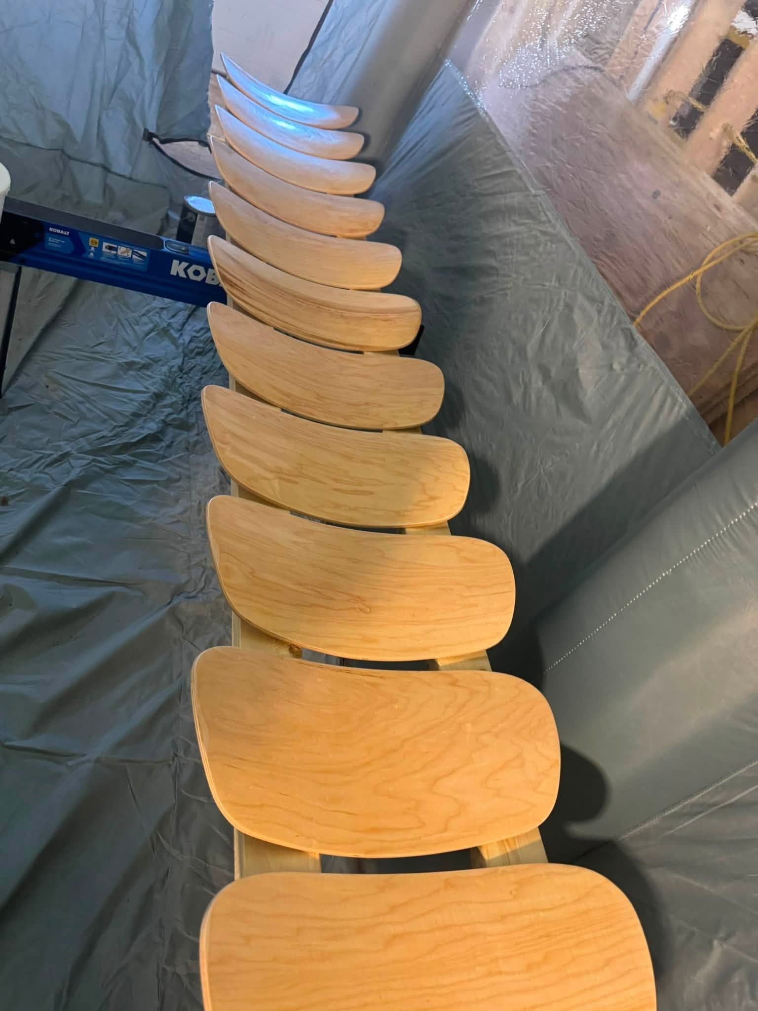 Row of light wooden chairs in a room, viewed from above