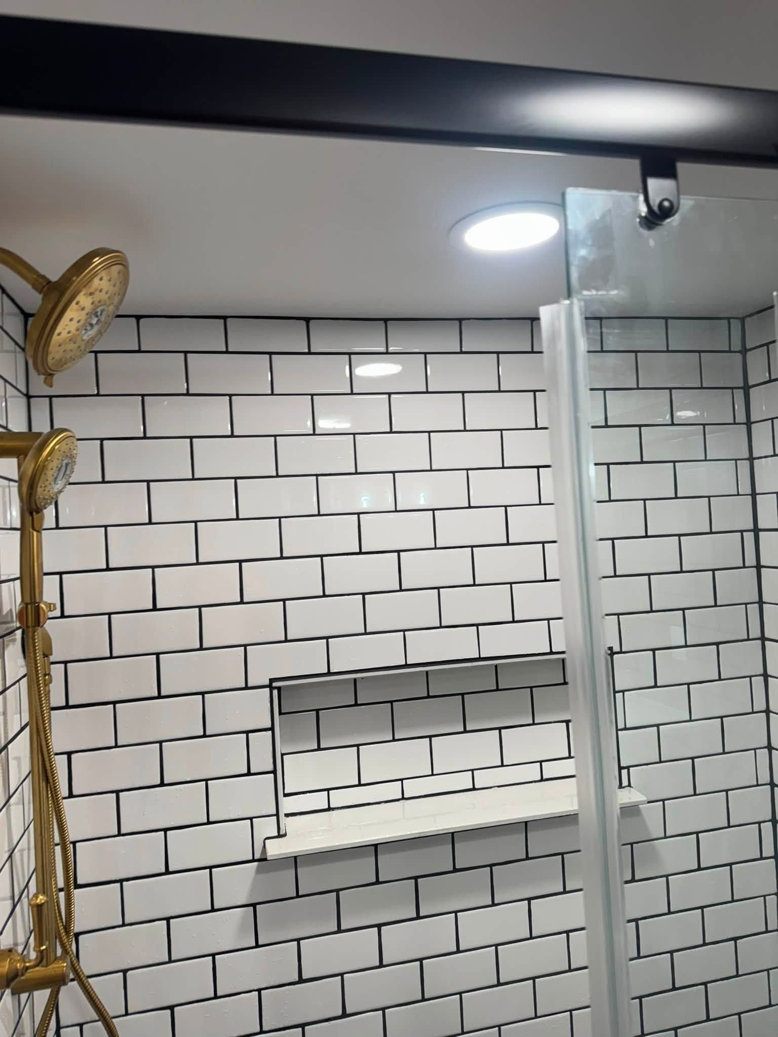 Bathroom wall with white subway tile, recessed shelf, shower rod, and ceiling light.
