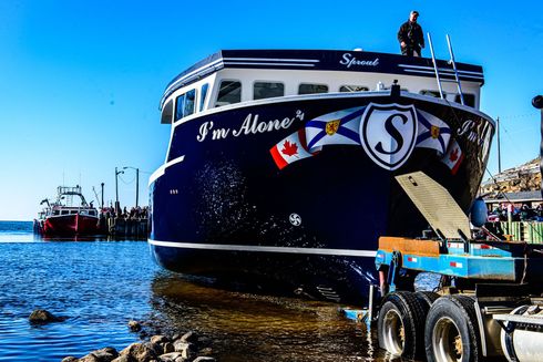 A blue and white boat with the name pur alone on it