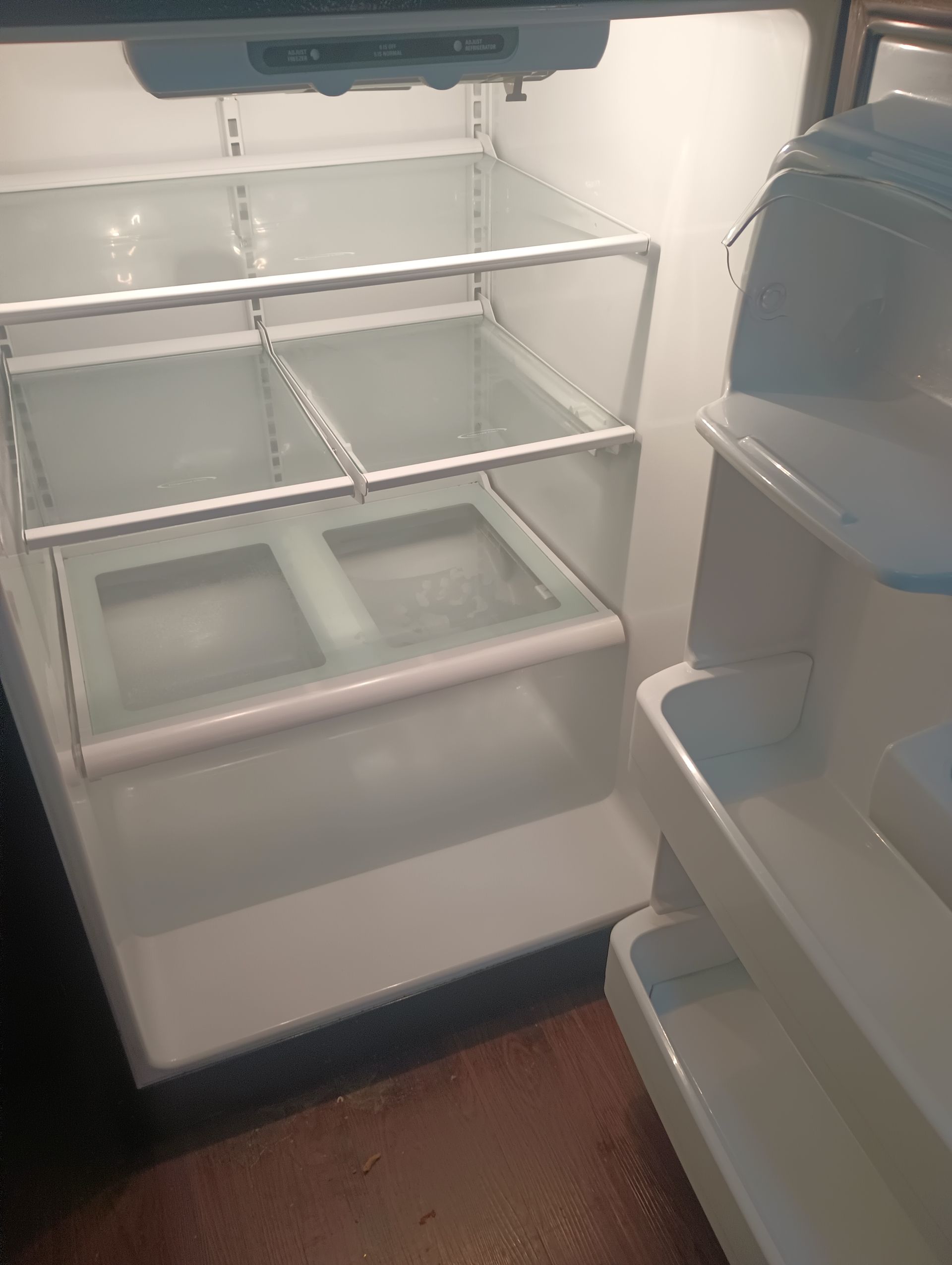 The inside of an empty refrigerator with a lot of shelves.