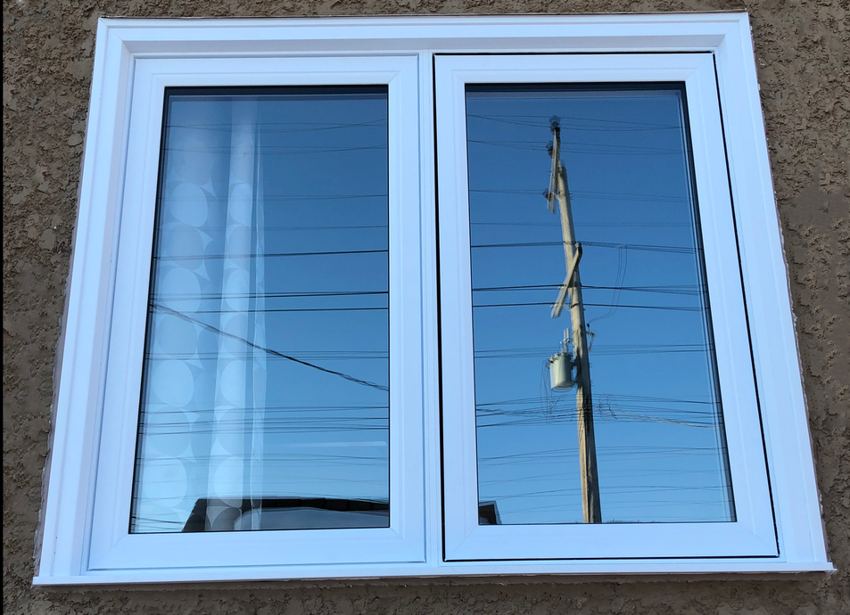 A white window with a reflection of a power pole in the window.