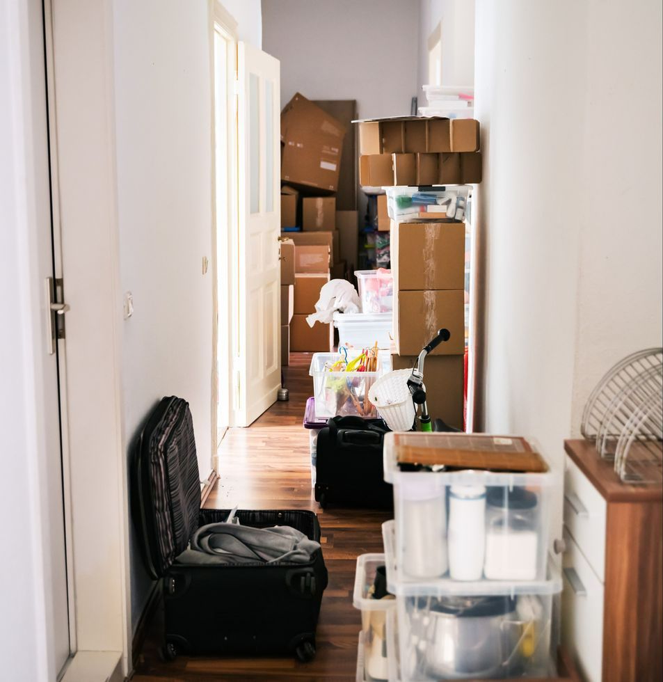 A hallway filled with boxes and a suitcase