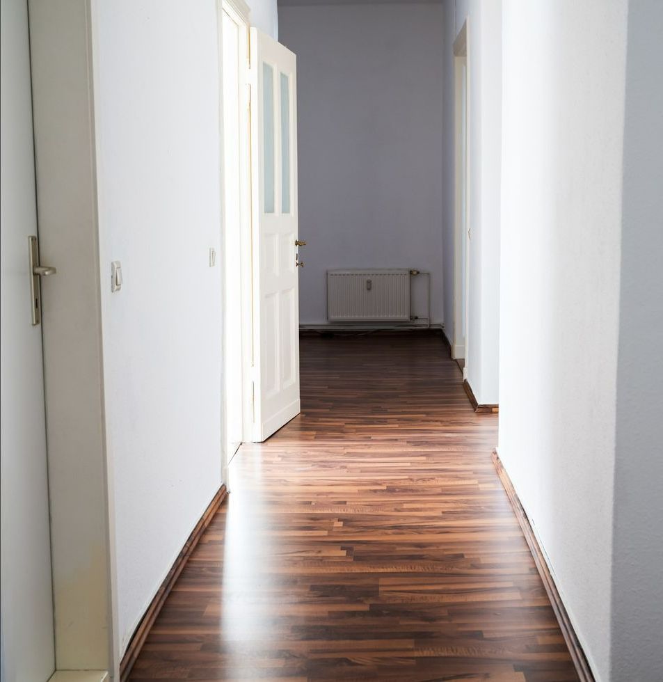 A hallway with hardwood floors and white walls