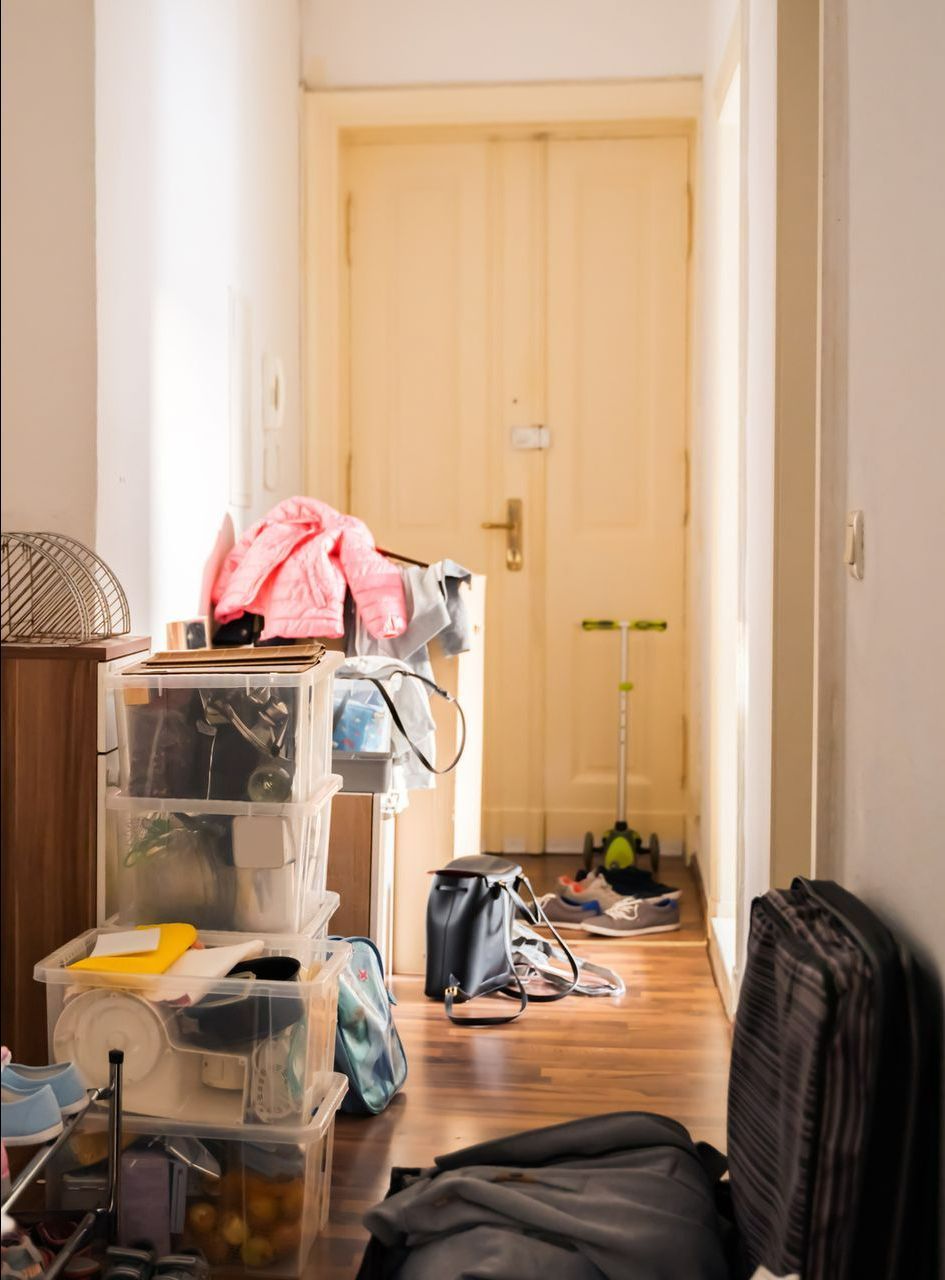A hallway with a lot of boxes on the floor and a suitcase on the floor.