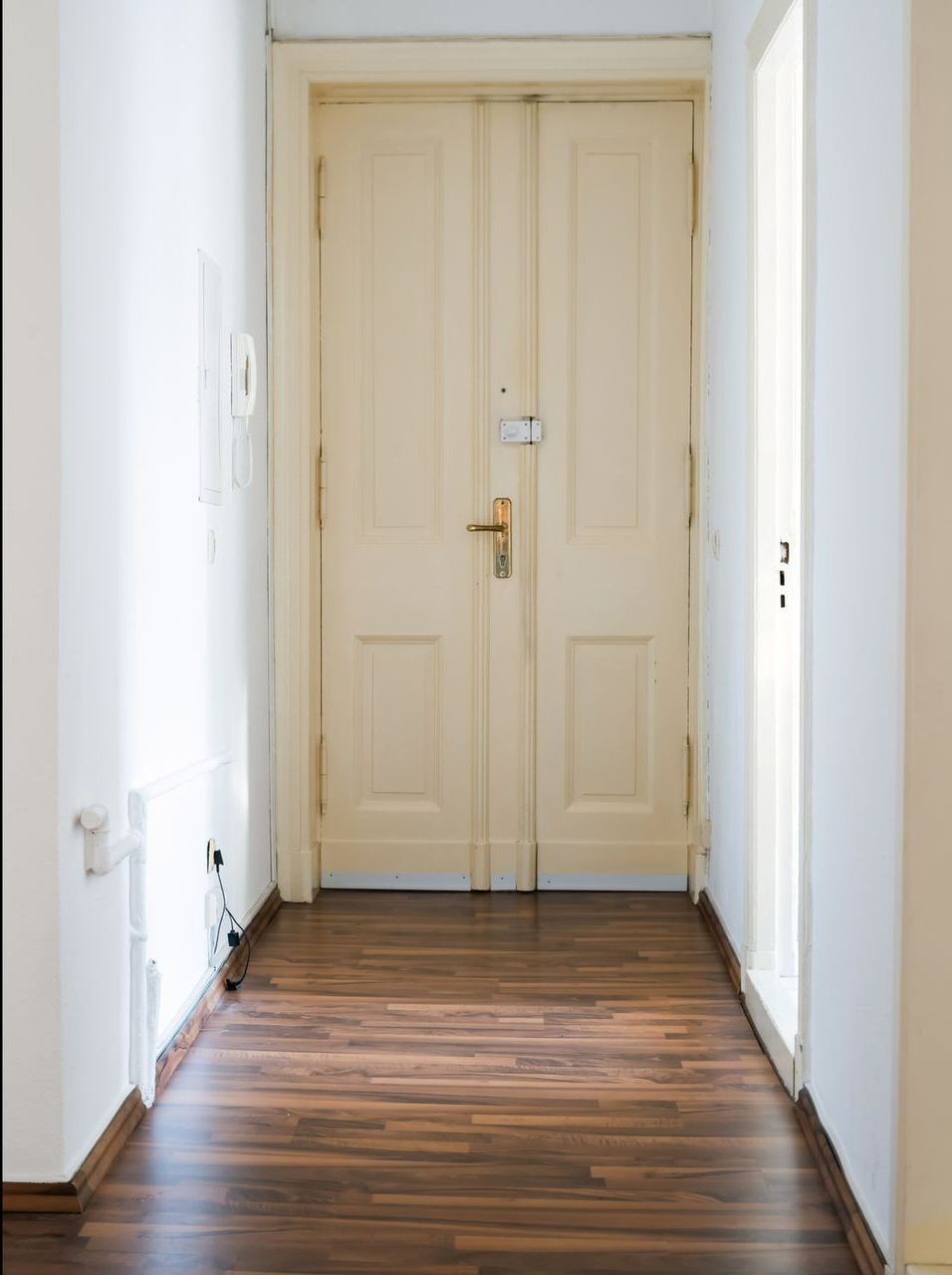 A hallway with white doors and a wooden floor